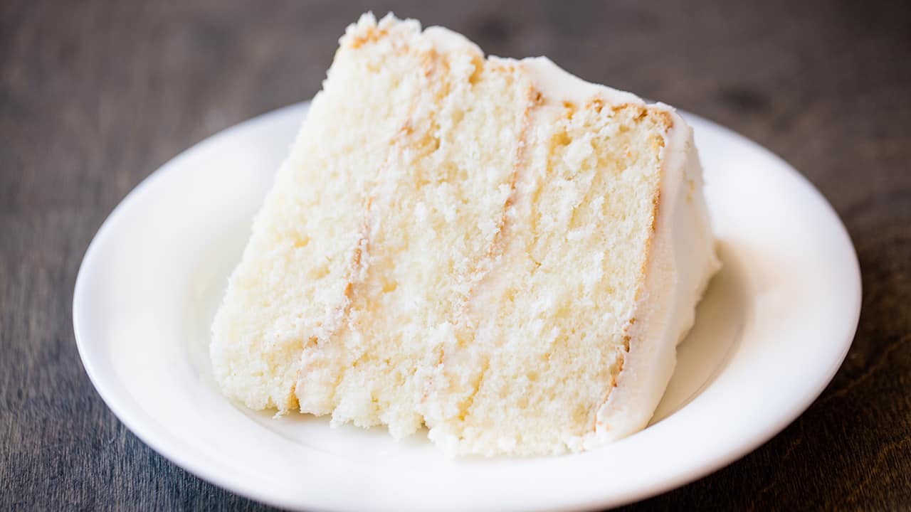 Slice of the most amazing white cake on a plate