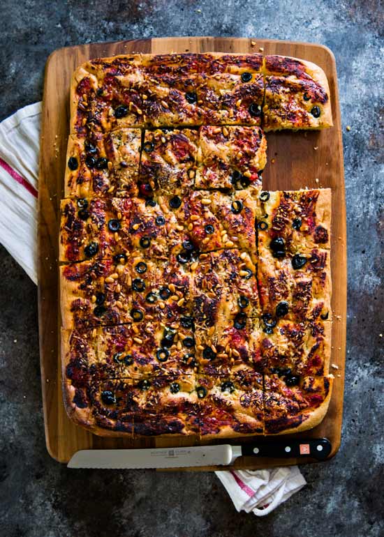 Easy Zesty Focaccia Bread cut into squares on a cutting board