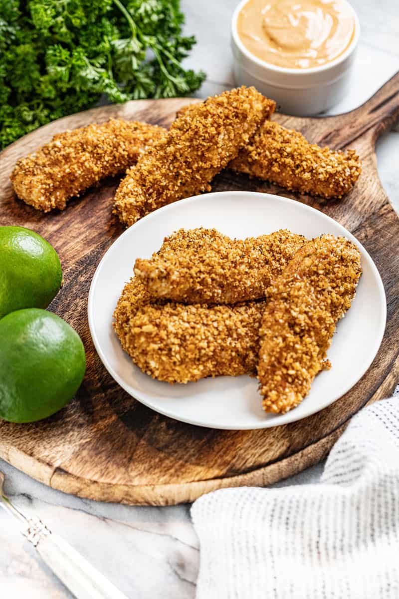 3 chicken tender strips on a white plate