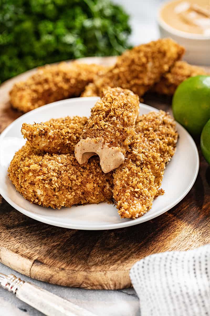 A pile of chili lime chicken tenders, one with a bit taken out of it