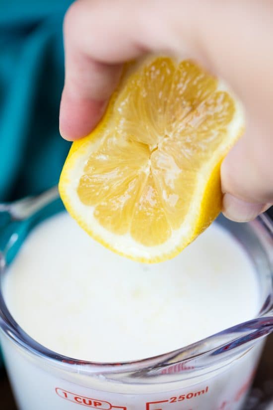 Rachel squeezes half a lemon into a measuring cup of milk
