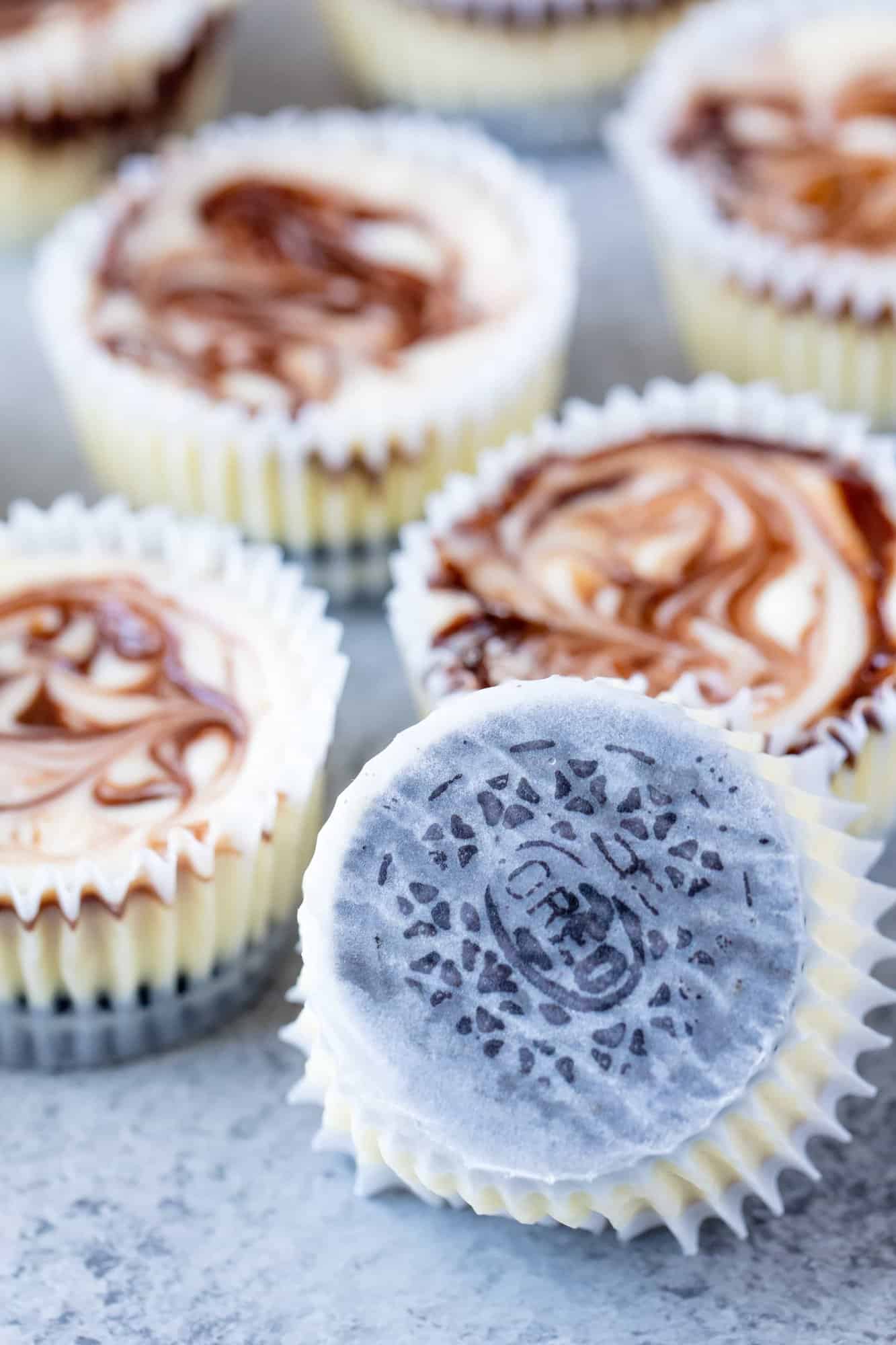 Fudge Swirled Oreo Bottom Cheesecake Cupcakes are a delicious twist on your standard cupcake. It's a fudge swirled mini cheesecake that sits on top of an Oreo cookie. What's not to love?
