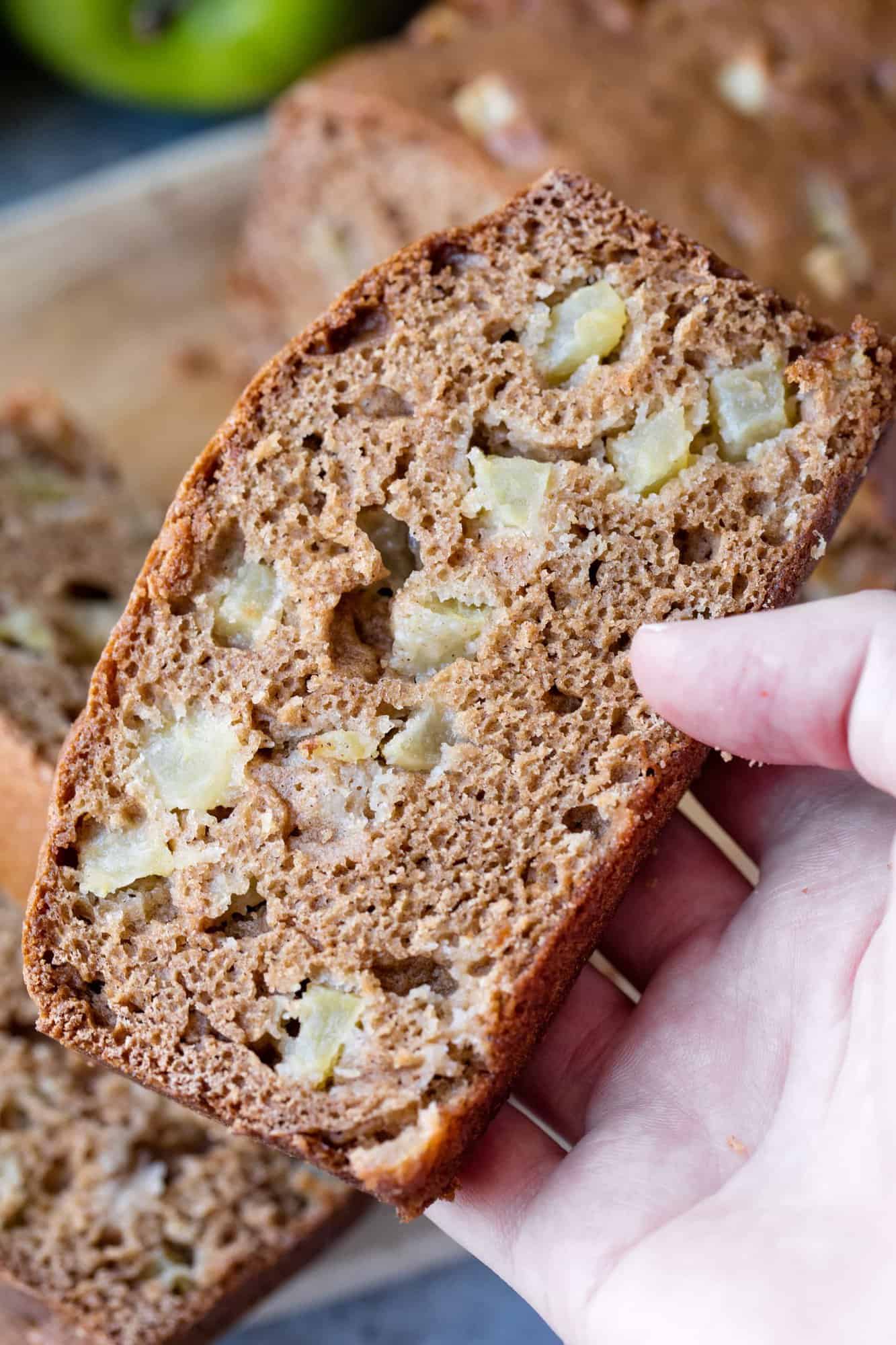 Hand holding a slice of apple bread
