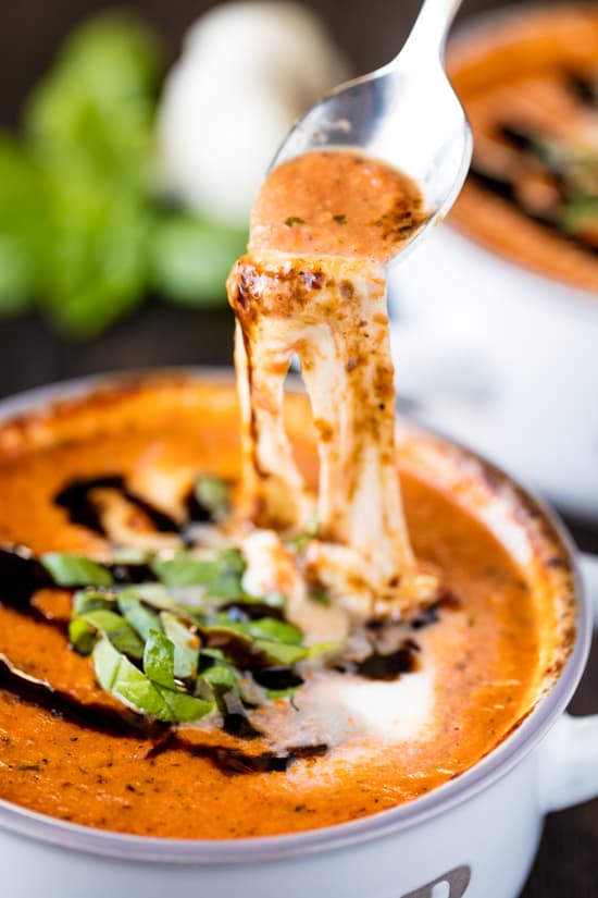 Caprese soup in a soup bowl with spoon taking a scoop