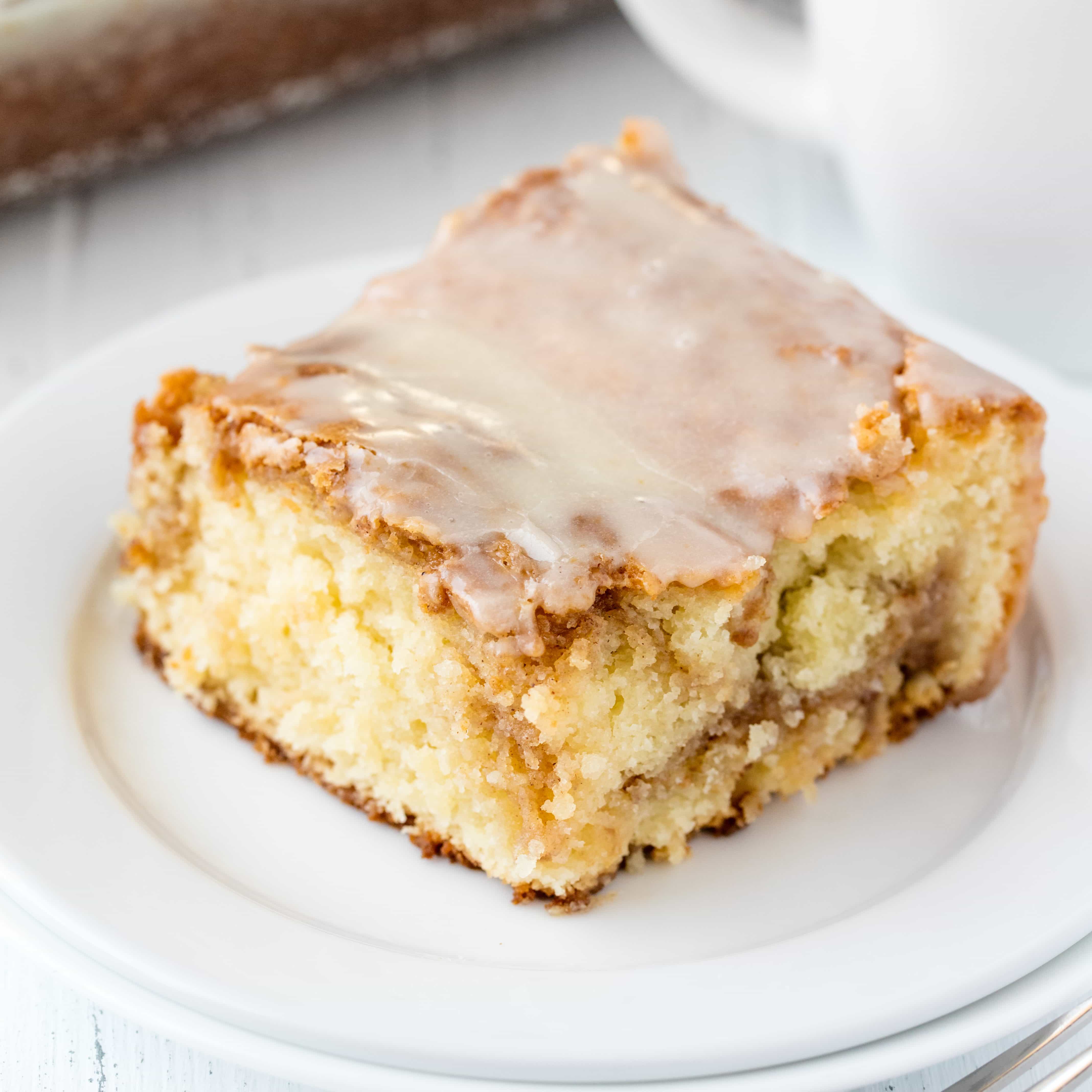 This super moist Cinnamon Roll Swirl Coffee Cake is worth making from scratch! Rich, moist coffee cake is swirled with a cinnamon roll filling and topped off with a simple glaze. This cake is to die for!