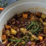 A pot of Honey Mustard BBQ Chicken garnished with fresh herbs