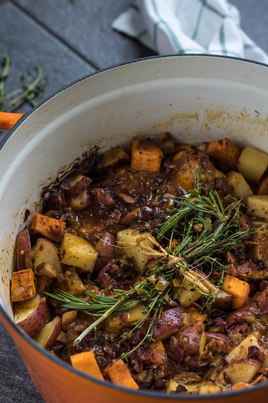 A pot of Honey Mustard BBQ Chicken garnished with fresh herbs