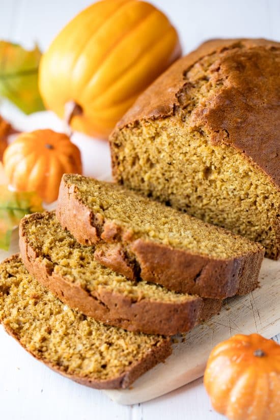 A loaf of sliced up Pumpkin Bread on a cutting board.