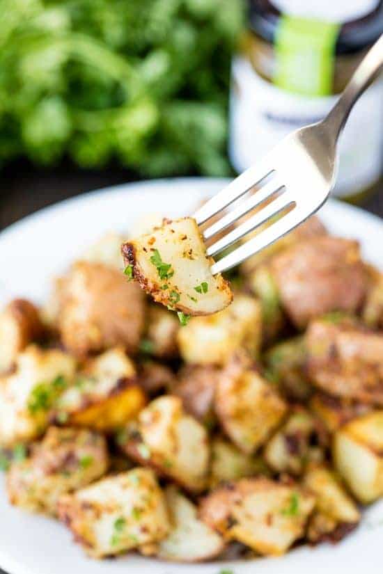 Fork holding a roasted parmesan pesto potato.