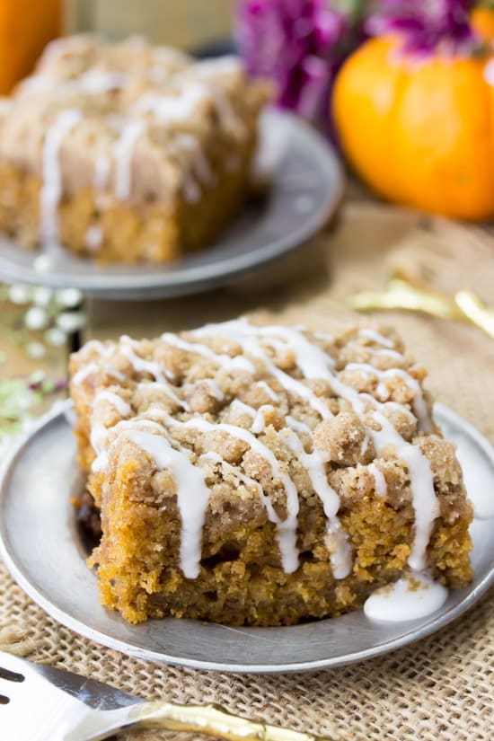Pumpkin Crumb Cake with a frosting on it sitting on a gray plate.