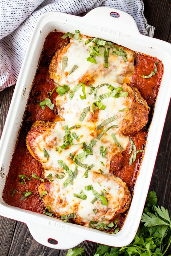 Overhead shot of untouched baked chicken parmesan in its pan. 