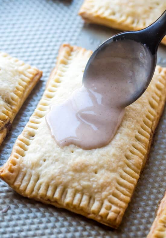 Icing is spread over baked Homemade Brown Sugar Pop Tarts