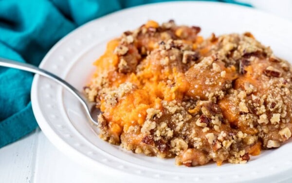 A plate full of sweet potato casserole with brown sugar and pecans