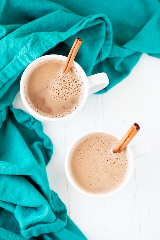 Caramelized Cinnamon Hot Chocolate served in two white ceramic mugs with cinnamon sticks 