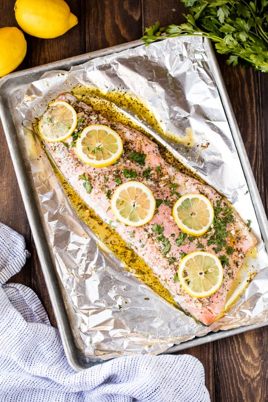 This easy Baked Salmon recipe is flavored with a simple garlic herb butter sauce Easy Garlic Herb Baked Salmon