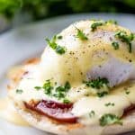 Perfect Eggs Benedict served on a plate, garnished with fresh chopped parsley