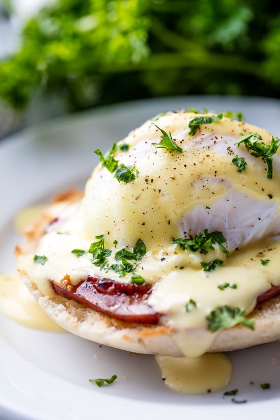 Perfect Eggs Benedict served on a plate, garnished with fresh chopped parsley