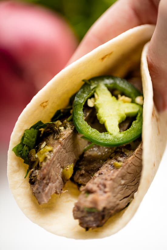 Slow Cooker Carne Asada Taco with slices of jalapeno and cilantro