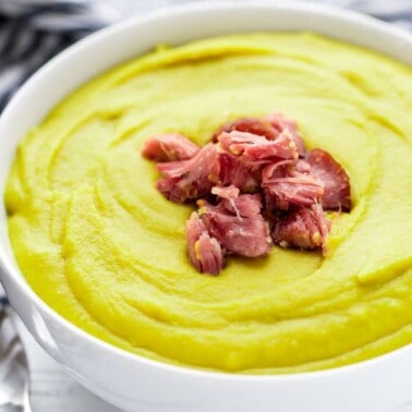 Split pea soup in a bowl garnished with ham