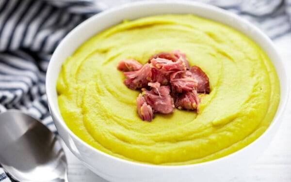 Split pea soup in a bowl garnished with ham