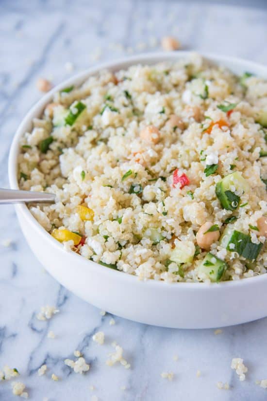 Quinoa Salad in a white bowl with a spoon 