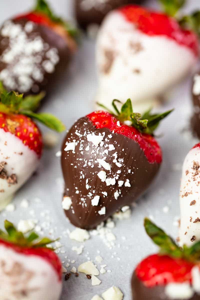 Close up of a Chocolate Covered Strawberry on wax paper.