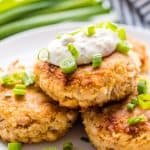 Three Crab Cakes stacked into a pyramid with tartar sauce on the top.