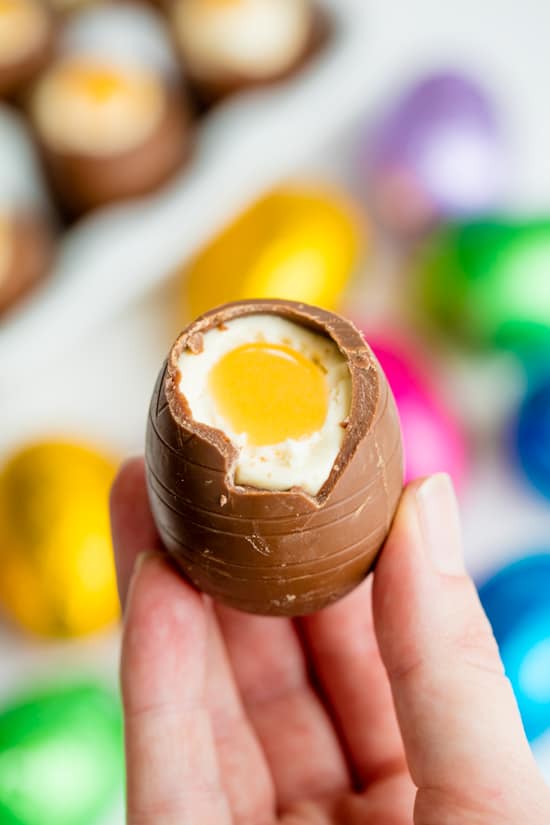person holding cheesecake stuffed chocolate Easter Egg 