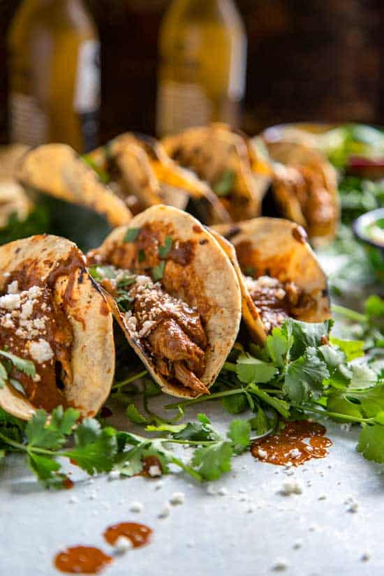 Chicken Mole tacos in taco holders on a counter.