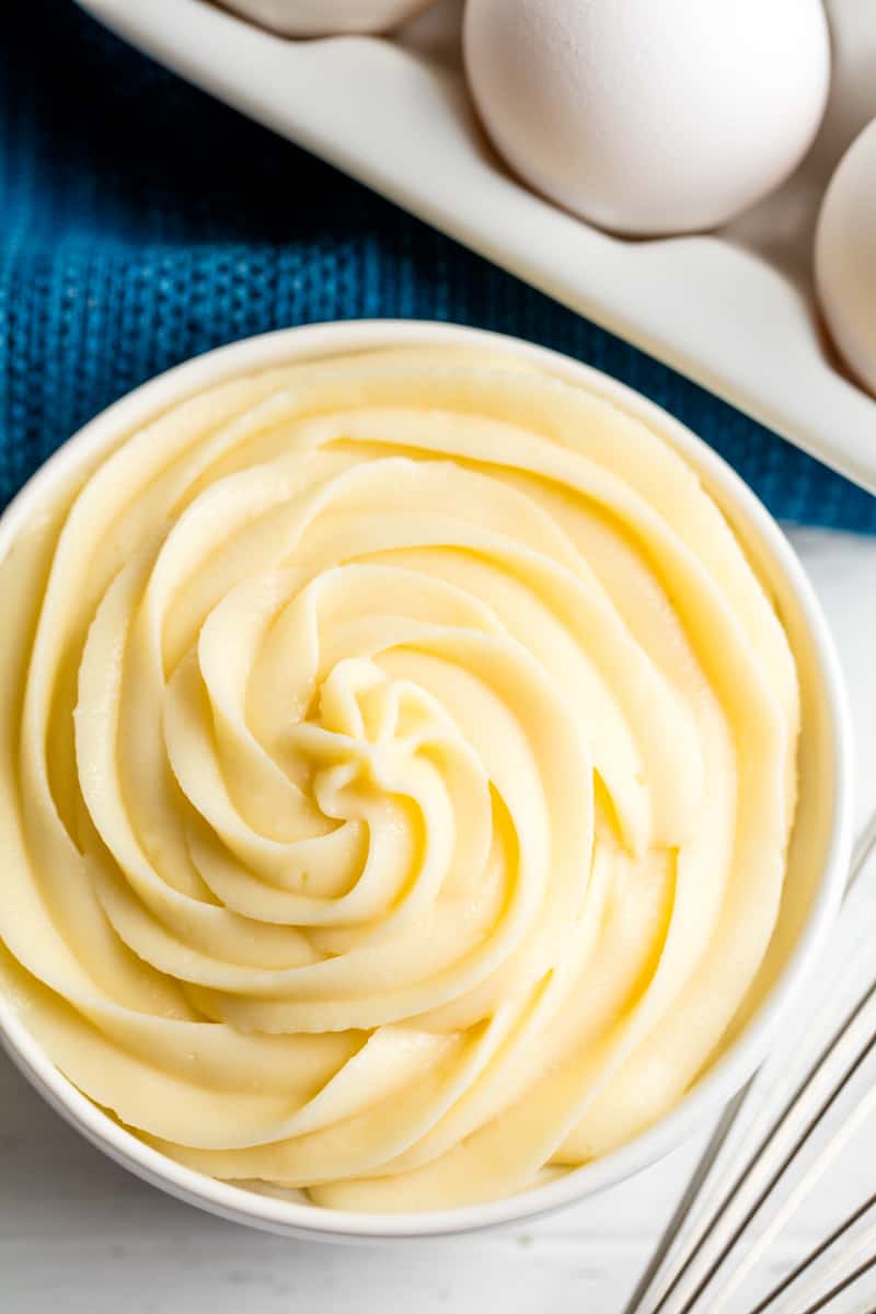 Bird's eye view of pastry cream swirled into a white bowl. 