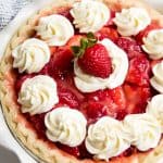 Bird's eye view of strawberry pie topped with whipped cream.