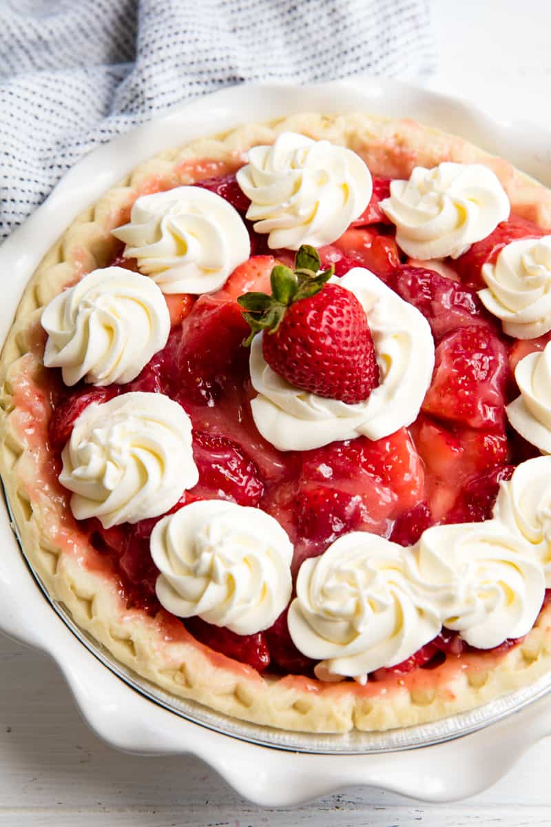 Bird's eye view of strawberry pie topped with whipped cream.