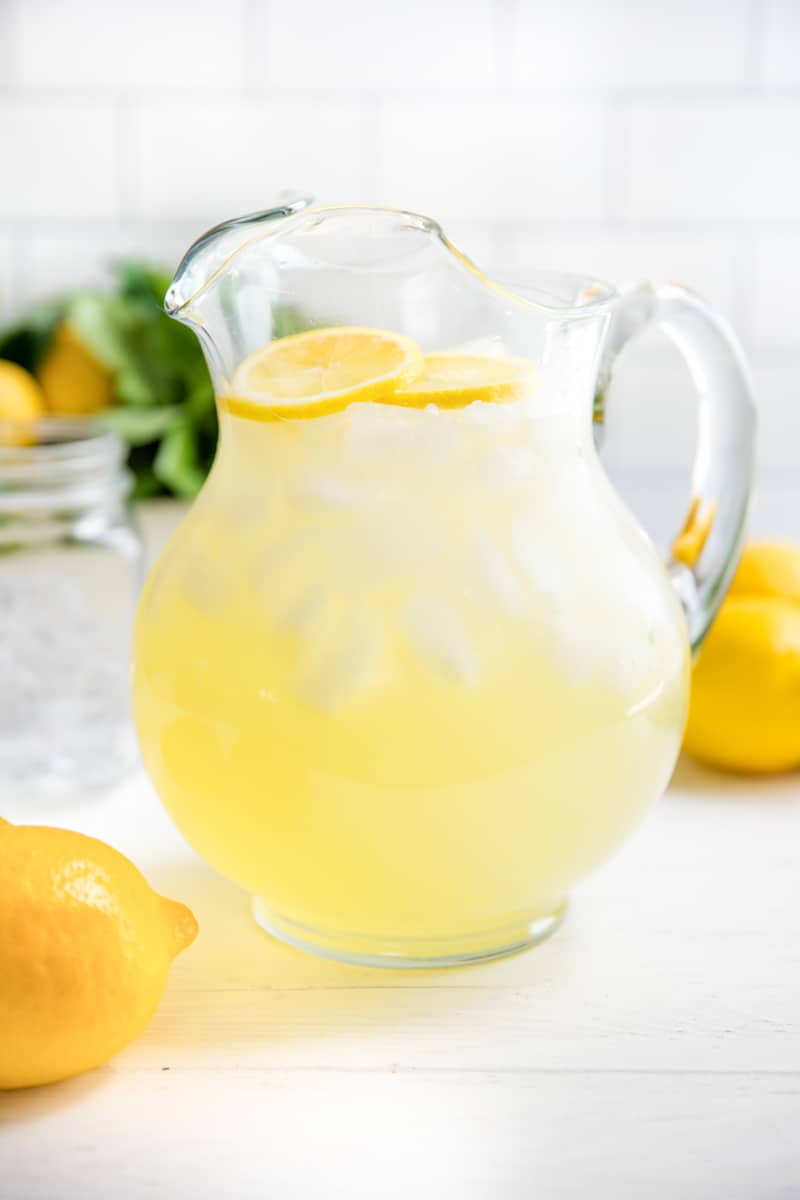 Homemade Lemonade in a glass pitcher with sliced fresh lemons