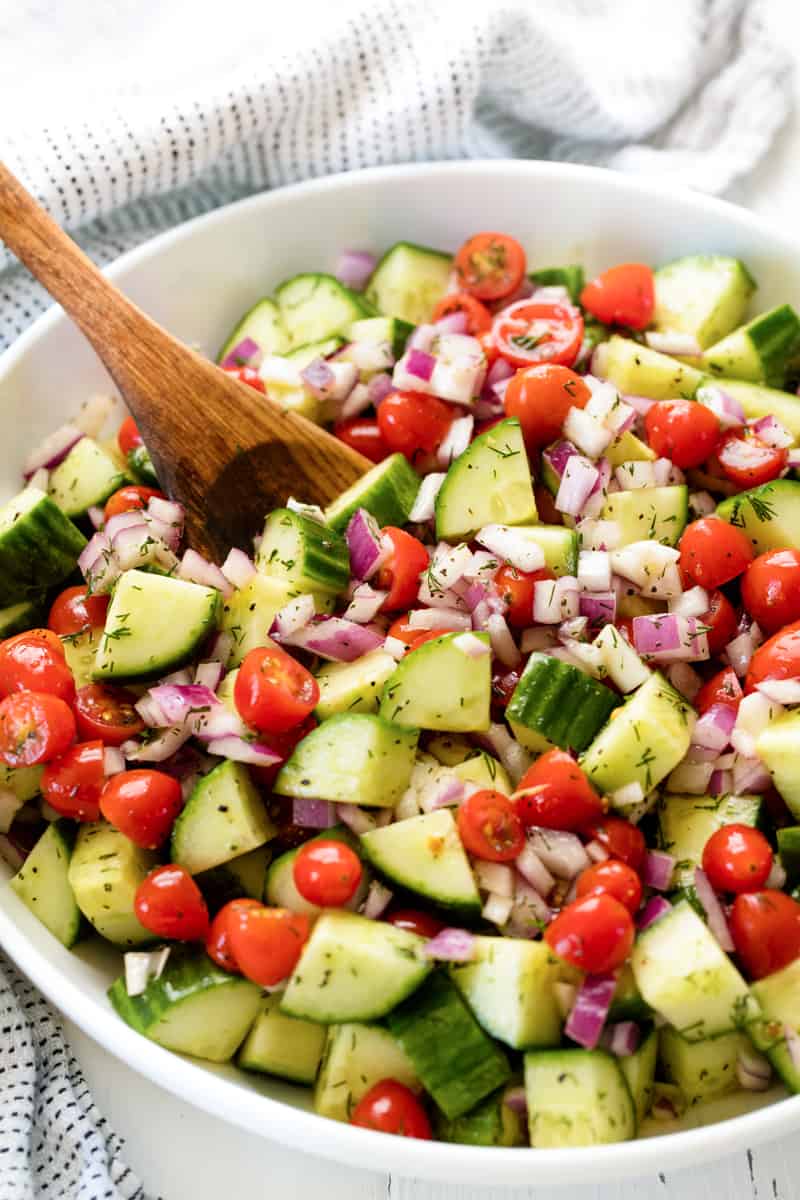 Cucumber Tomato Salad with cherry tomatoes, cucumber and red onion, tossed with lemon dill dressing in a bowl