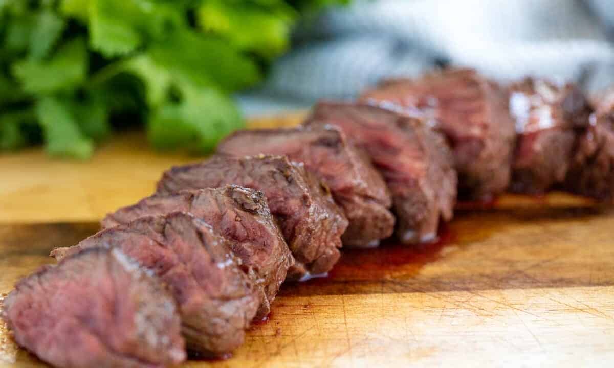 Hanger steak sliced up on a cutting board.