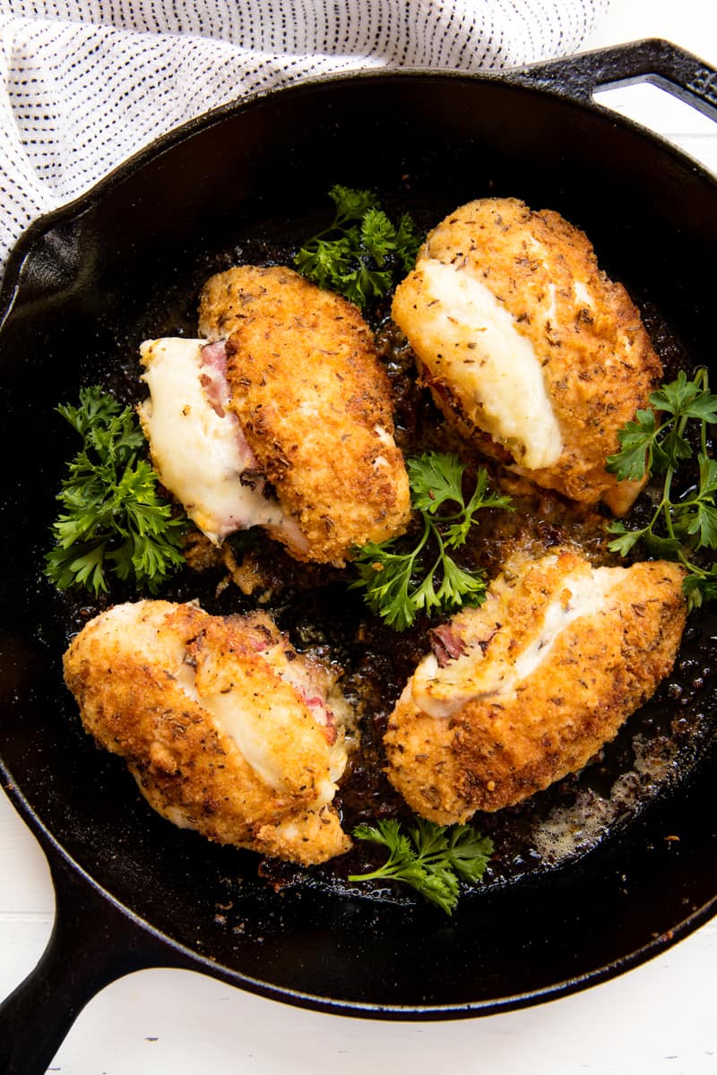 Bird's eye view of Reuben Stuffed Chicken and parsley in a cast-iron skillet.