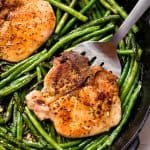 Bird's eye view of Pork Chops and Green Beans in a cast-iron skillet.