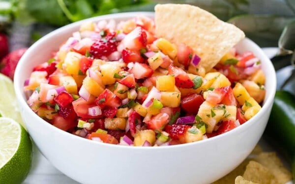 Strawberry Pineapple salsa in a white bowl with a chip in it.