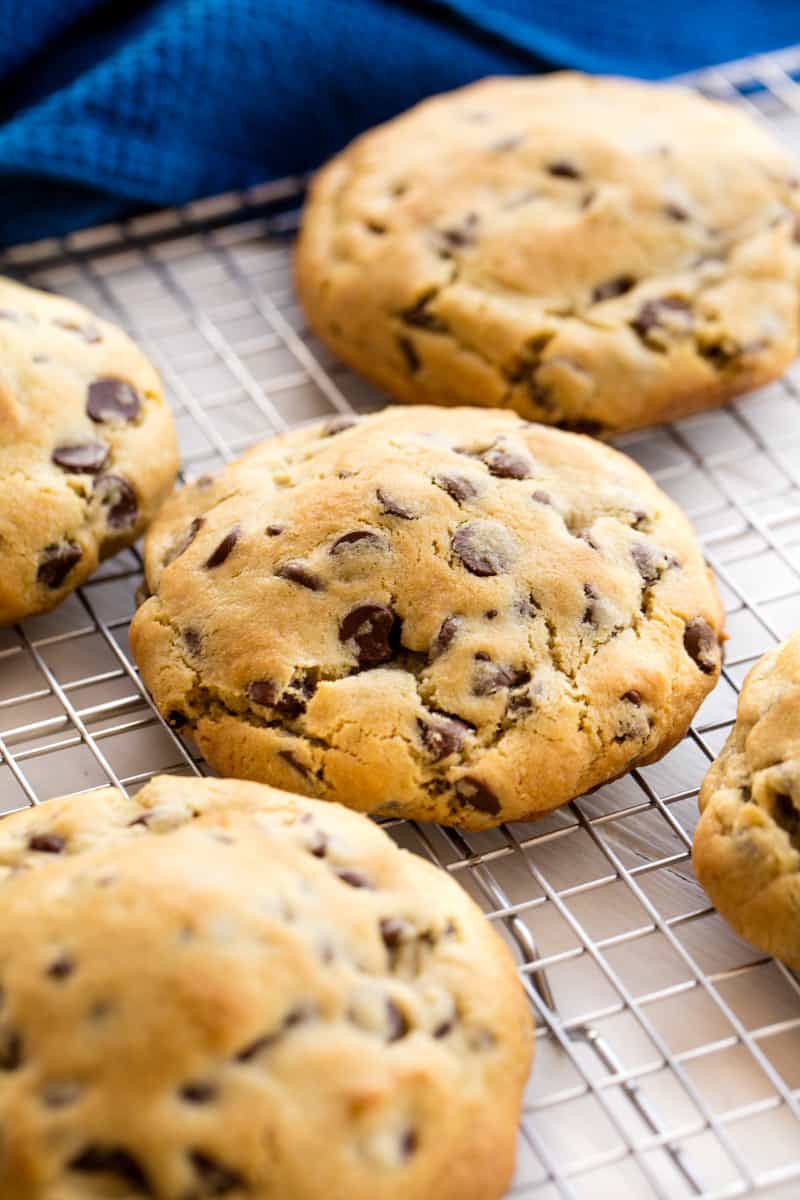 Bakery Style Chocolate Chip Cookies are cooling on a wire rack.