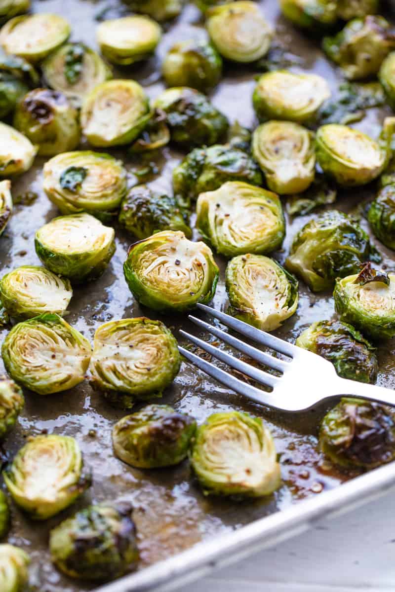 Roasted Brussel Sprouts on a baking sheet with a fork on it.