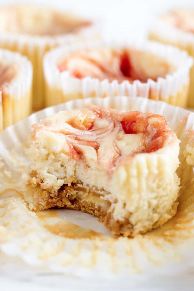 Strawberry Cheesecake Cupcake unwrapped with a bite taken out of it.