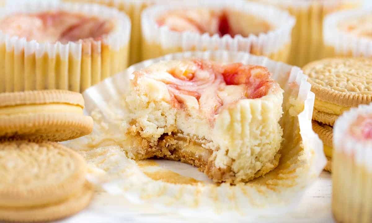 Strawberry Cheesecake Cupcake unwrapped with a bite taken out of it.