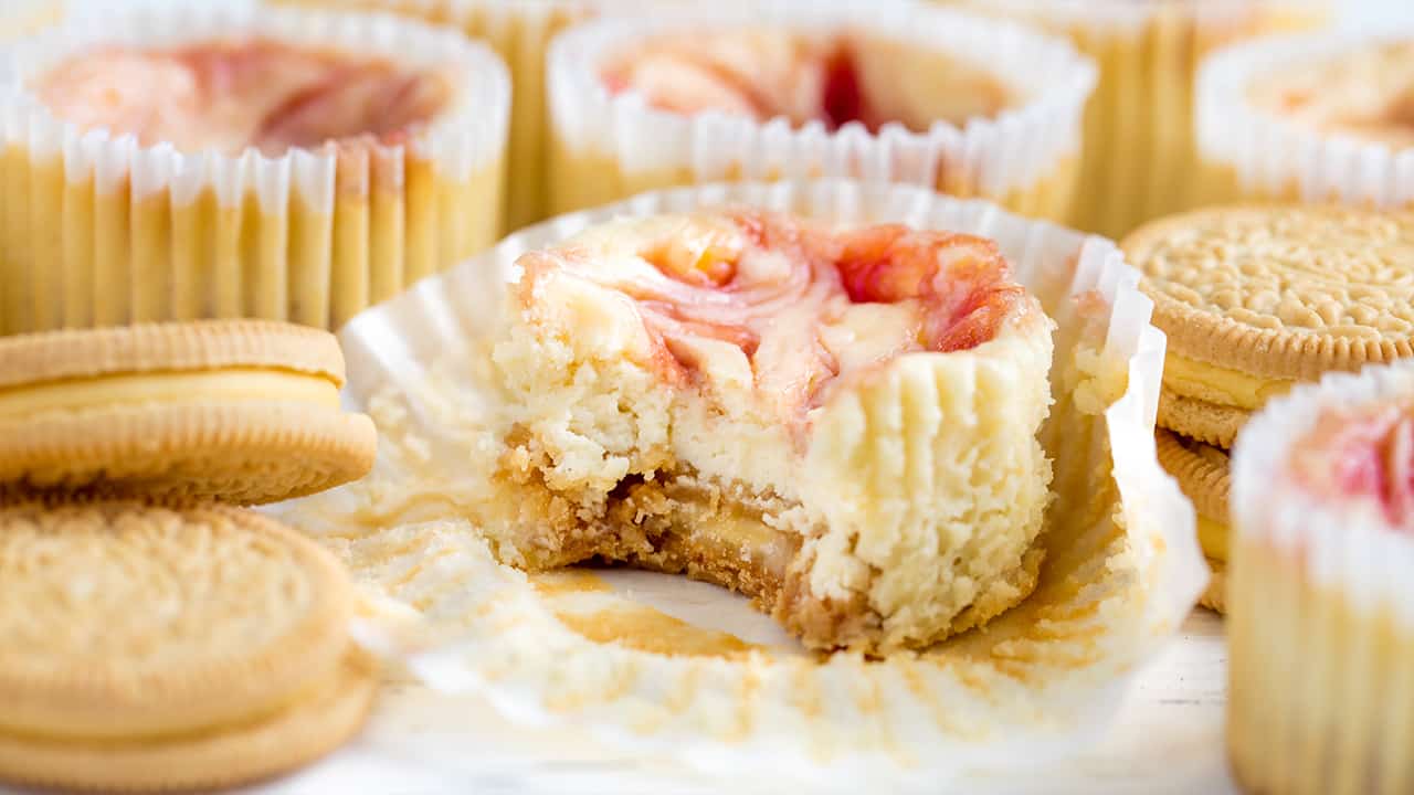 Strawberry Cheesecake Cupcake unwrapped with a bite taken out of it.
