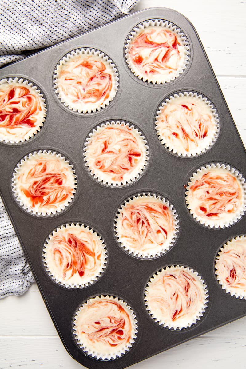 Bird's eye view Strawberry Cheesecake Cupcakes in a muffin pan.