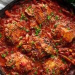 Bird's eye view of Chicken Cacciatore in a cast-iron skillet.