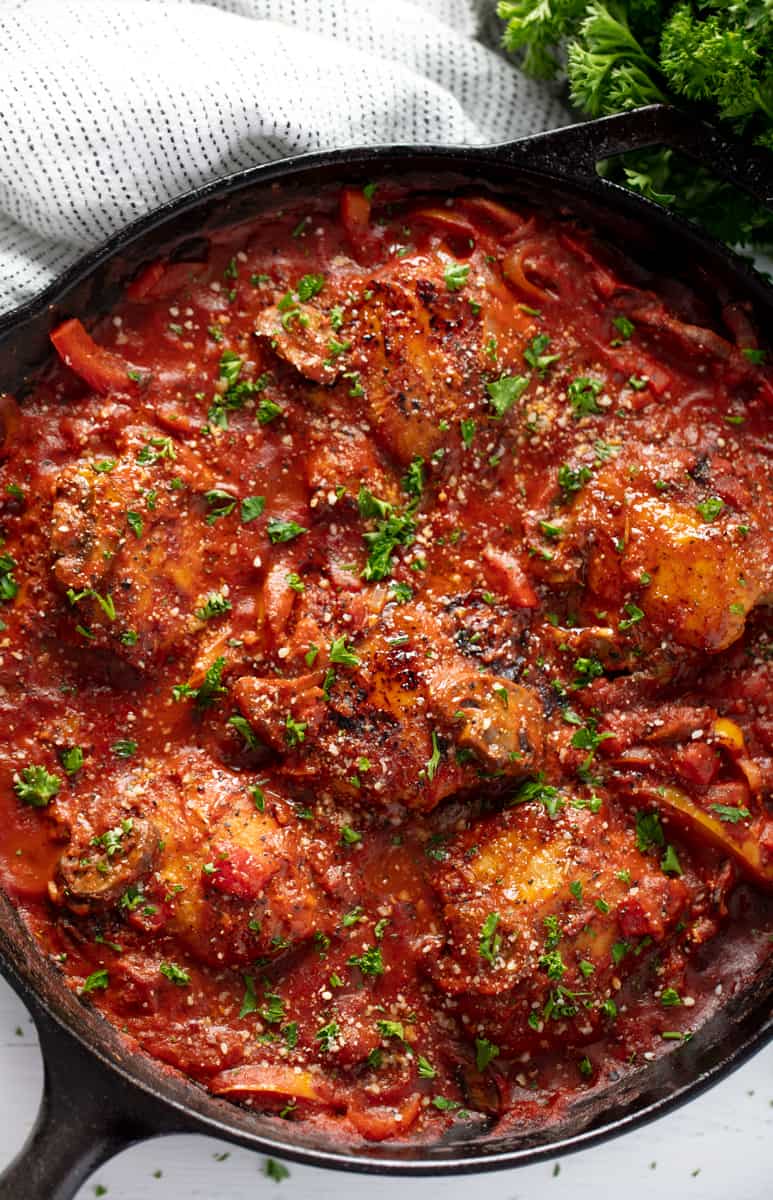 Bird's eye view of Chicken Cacciatore in a cast-iron skillet.