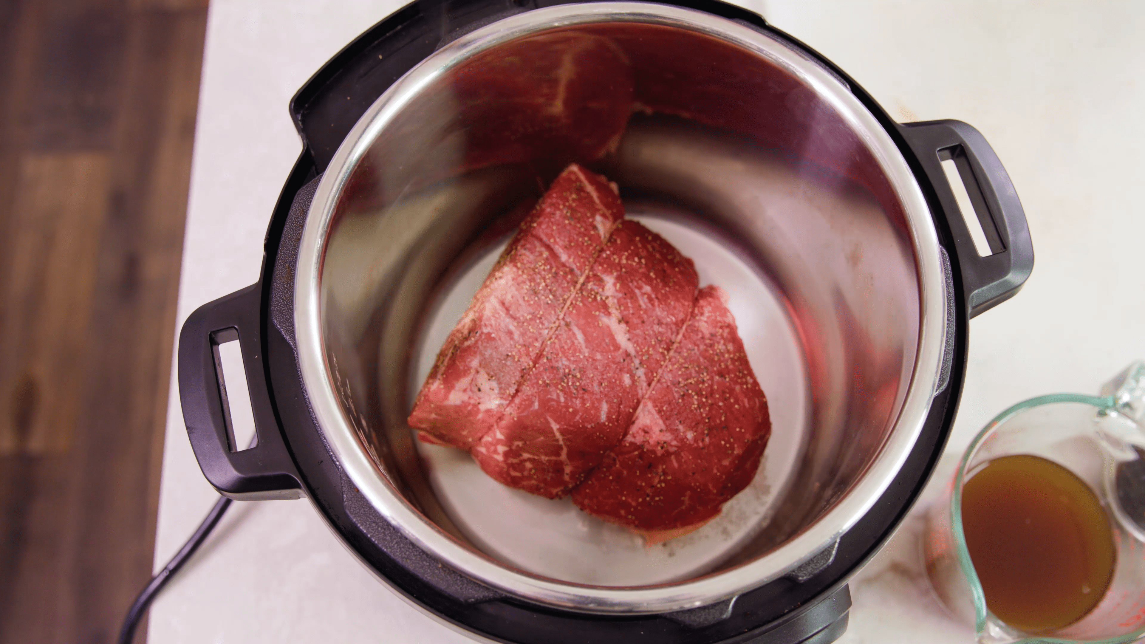 Bird's eye view of a pot roast in a pressure cooker.