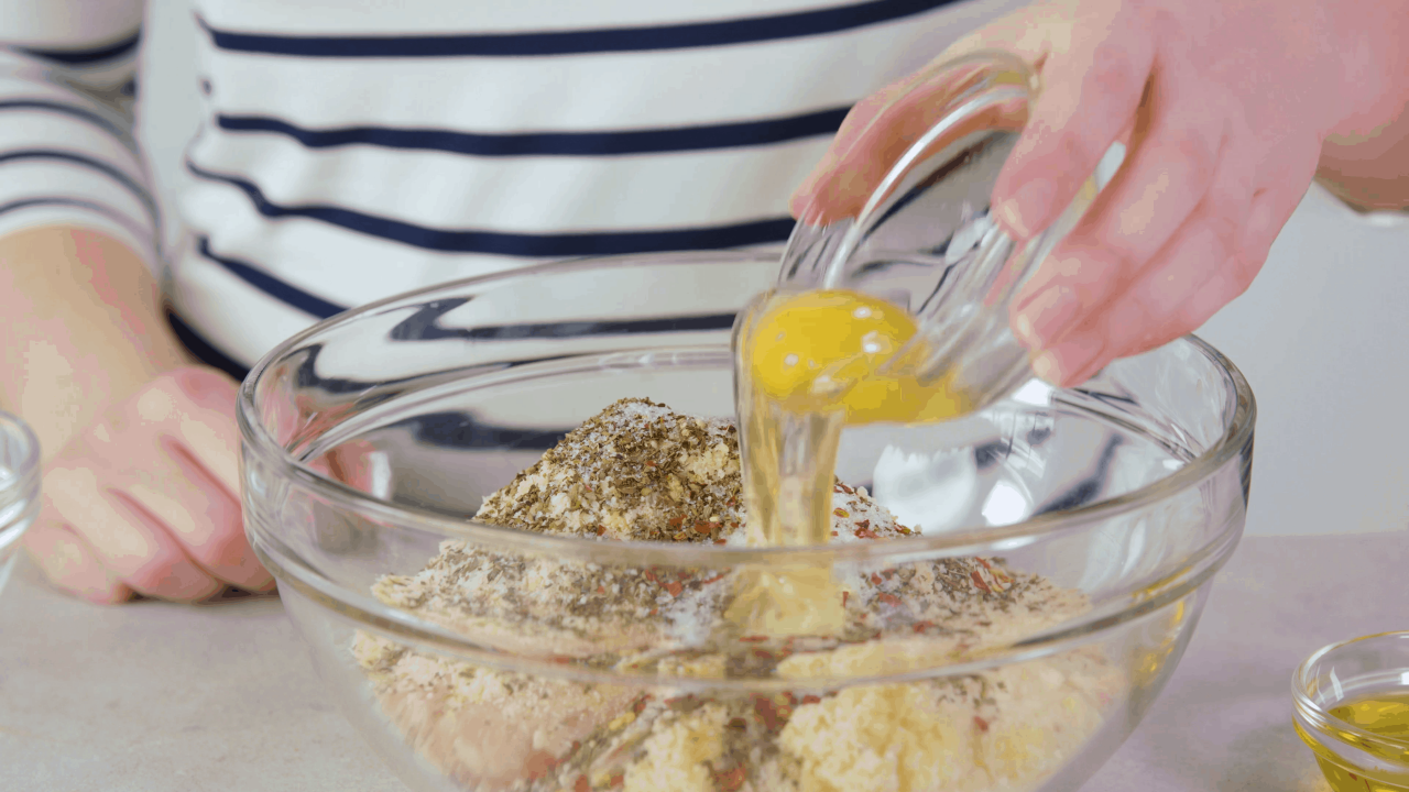 Eggs being poured into a Ground Chicken Meatball Mixture