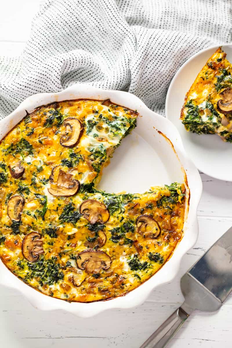 Bird's eye view of Spinach Quiche in a dish with a slice missing in it.