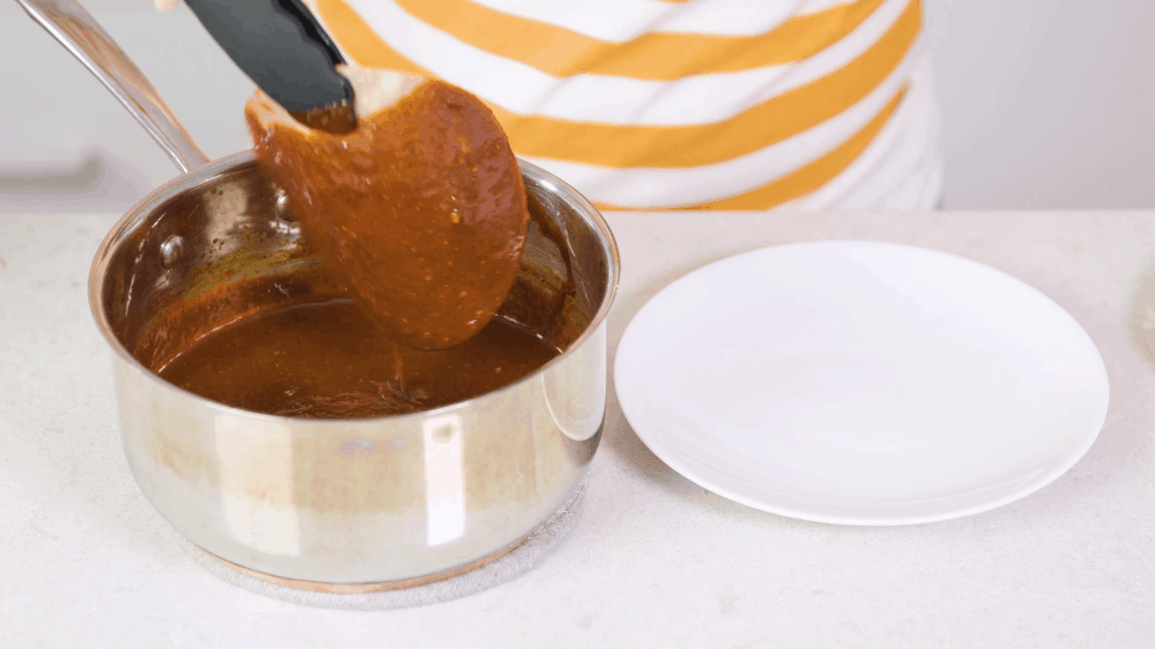 Dipping tortilla into enchilada sauce